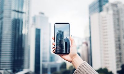 Person taking picture of city with phone